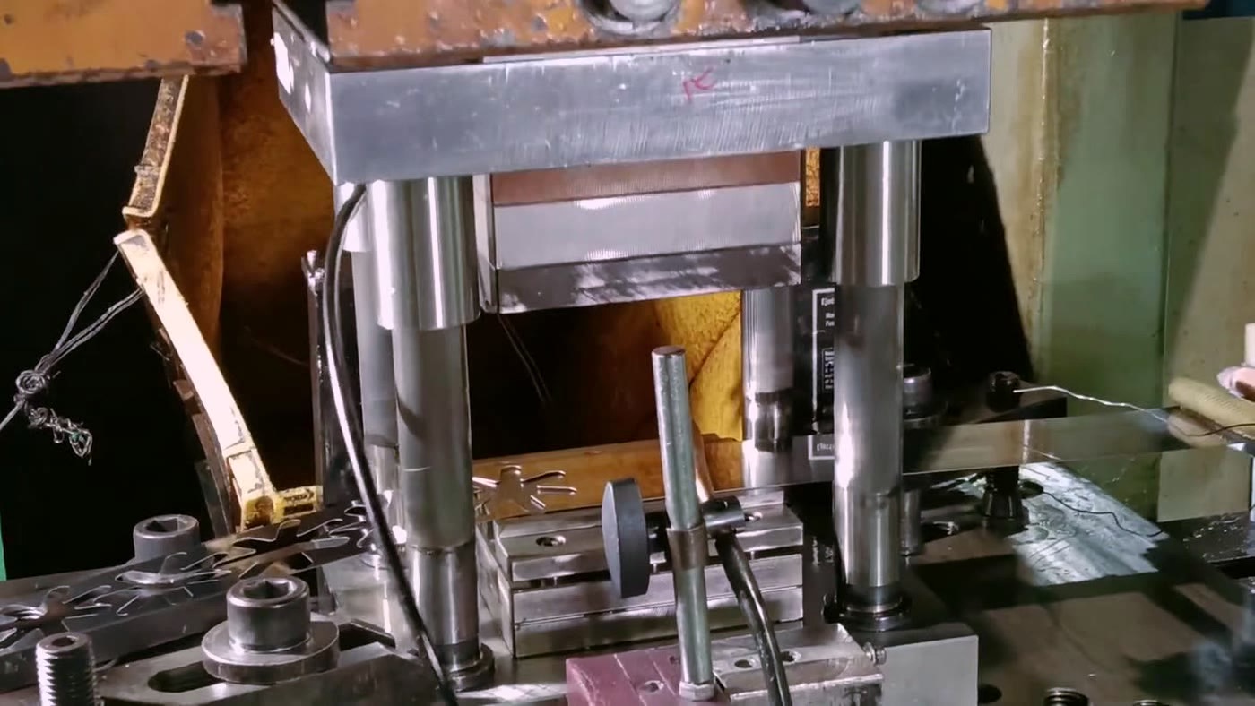 Hydraulic press die line with fresh stamped mount blanks lying on the bed