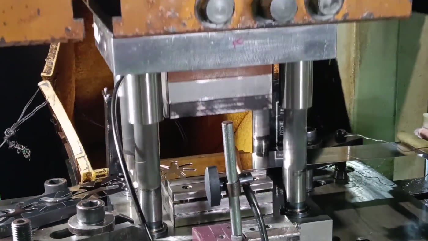 Four-post stamping press with polished chrome guide posts and punched blanks on the EmoryMfg shop floor